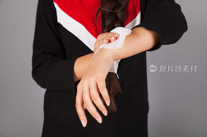 女人的手正在用纸巾擦干。