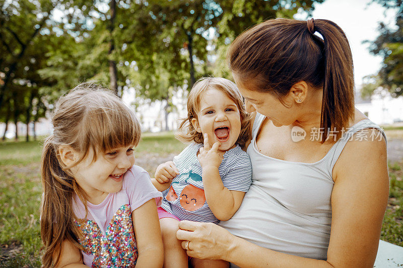 夏天的下午，怀孕的母亲带着女儿在公园里