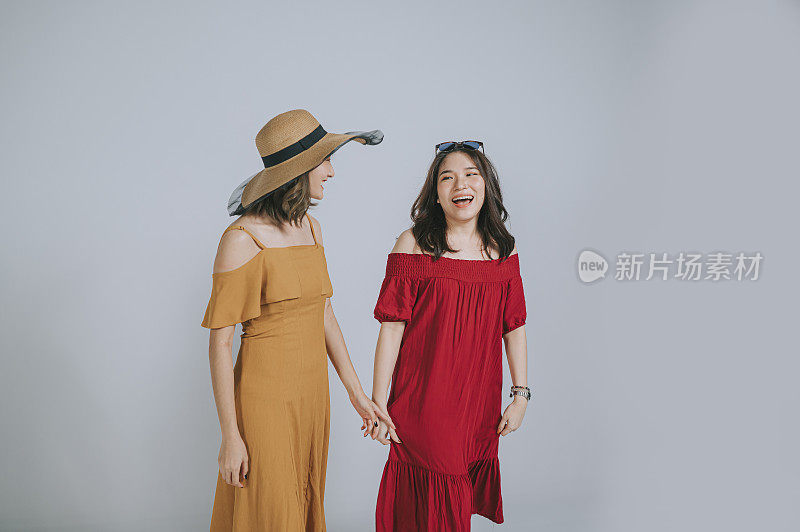 时尚的亚洲中国女性朋友们享受着微笑的夏天穿工作室拍摄剪出的灰色背景