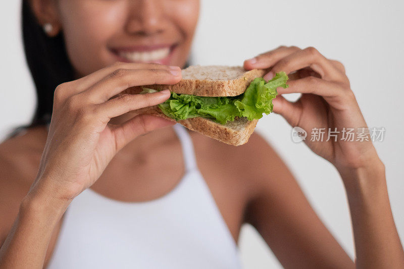 亚洲妇女吃素食三明治