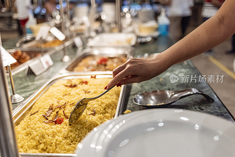 在自助餐厅里，托盘上有煮熟的食物