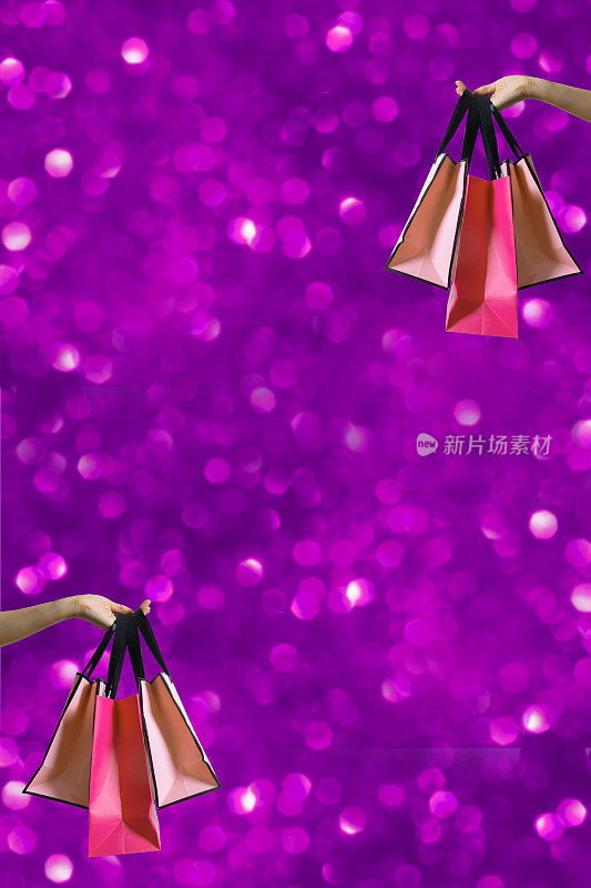 购物袋在女性手中与节日sparkles在紫色的柏格背景与复制空间垂直格式