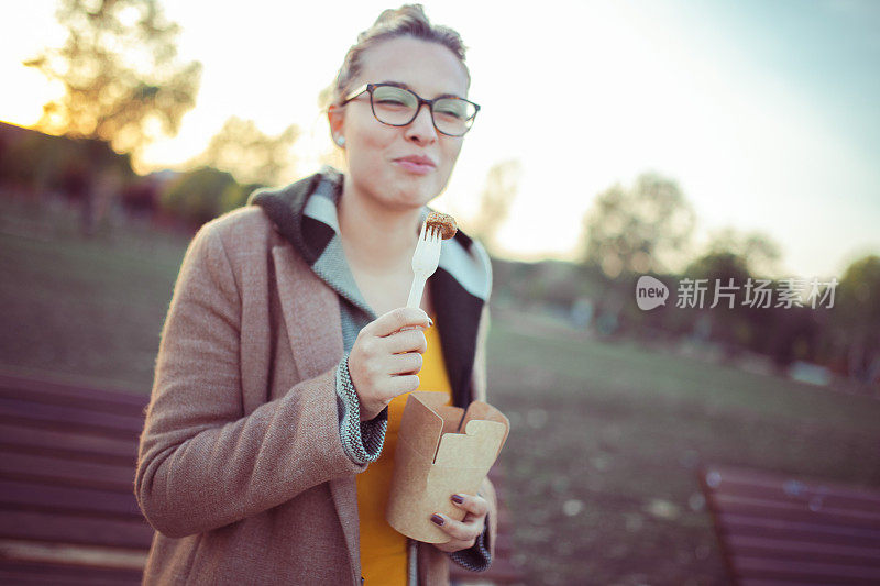 这个女人喜欢她在公园里吃的美味的快餐。