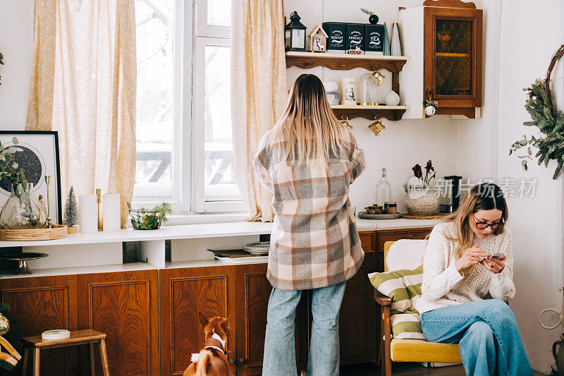 年轻的白人妇女做饭在厨房的乡村房子在冬季假期与家人。