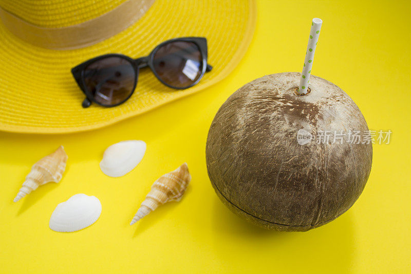 草帽，太阳镜和黄色背景的草编椰子