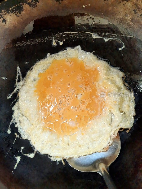 在平底锅中煎炸猪肉煎蛋卷。