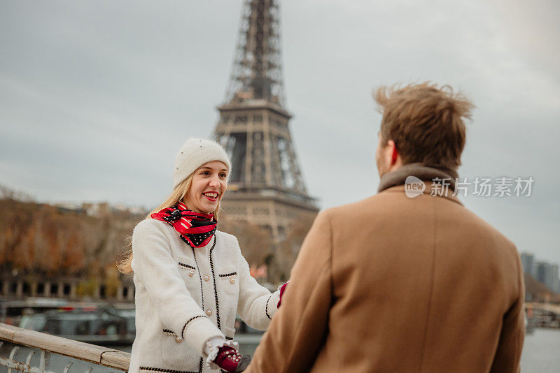 一个金发女人在埃菲尔铁塔前对着男友微笑的特写镜头