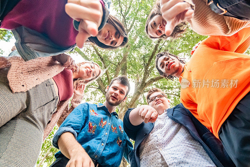 一群人，混合种族和性别的大学生围成一圈，互相拥抱着看着镜头，评判和羞愧