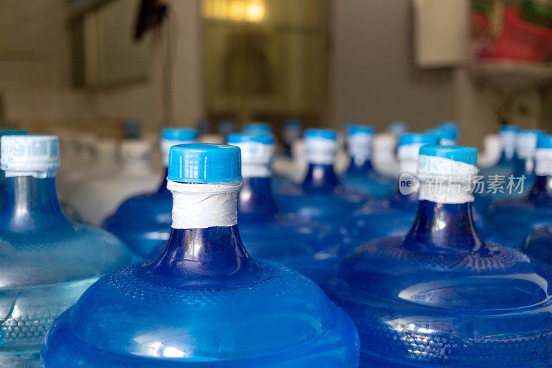 装有饮用水的蓝色水加仑已经用塑料密封密封在饮用水厂等待运送