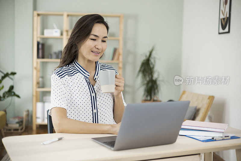 亚洲女商人在网上工作时享受咖啡