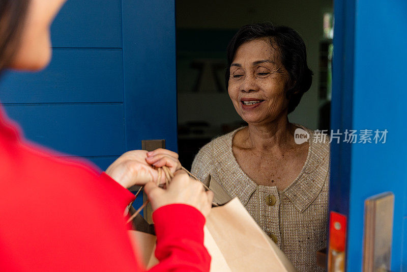 女人在家里给老人送食物。