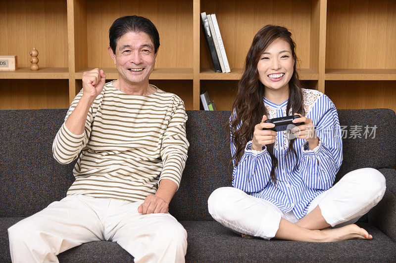 父亲和女儿在玩电子游戏