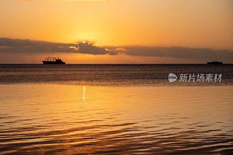 毛里求斯汤博湾，渔船和商业油轮上的夕阳