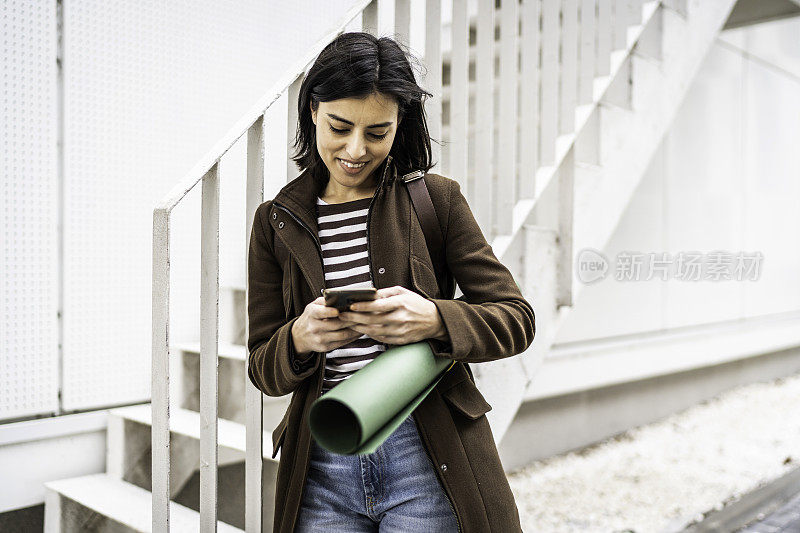 年轻快乐的女人在户外使用智能手机