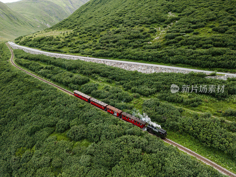 从空中俯瞰蒸汽火车经过瑞士阿尔卑斯山的高山草地