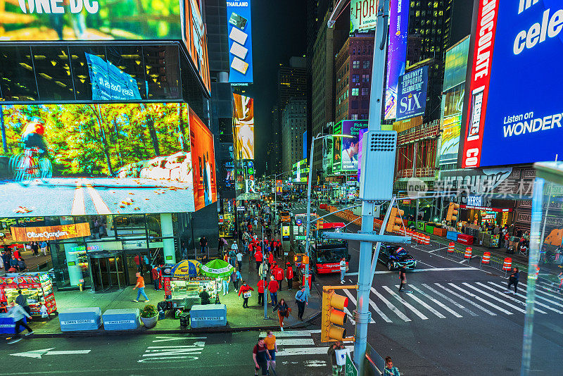 曼哈顿百老汇夜间的美丽景色，交通流量，行人和摩天大楼立面上的LED广告面板。