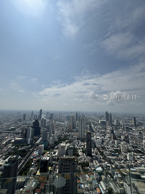 素坤逸市中心，曼谷市中心，泰国城市景观摩天大楼天际线从玻璃安全屏障后，朝披耶河，线性城市化，阳光明媚的蓝天与蓬松的白云，高架视图