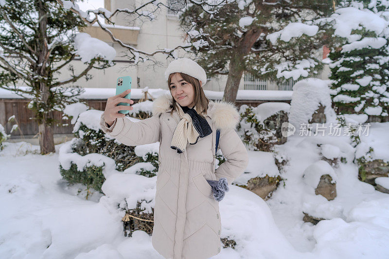 美丽的女游客享受他们的日本之旅在雪的冬天