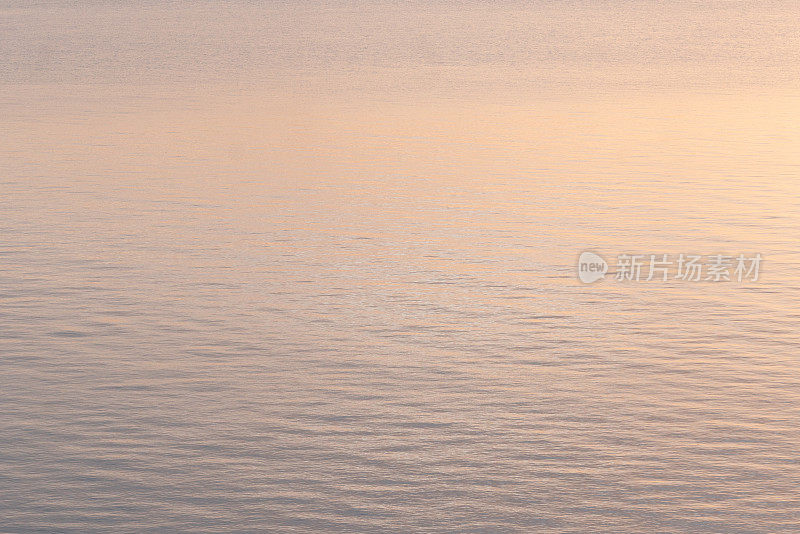 清晨的阳光照在平静的海面上