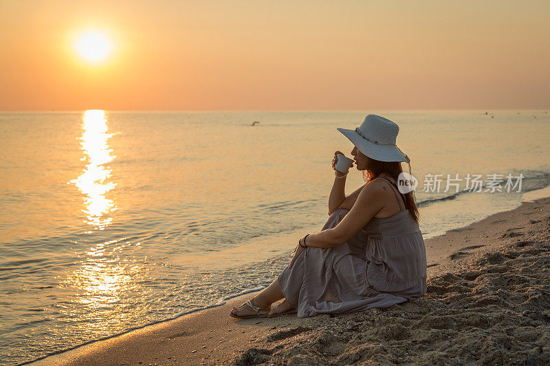 年轻女子喜欢早上在海滩上喝咖啡