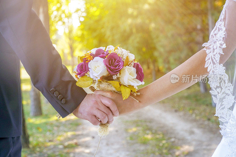 婚礼细节的特写。新郎的手牵着新娘的手。户外婚礼