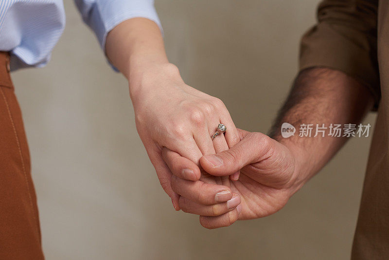 近距离摄影棚拍摄的陌生的订婚男女温柔地握着他们的手