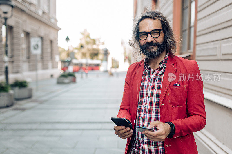 一个成熟的男人站在街上，在网上购物