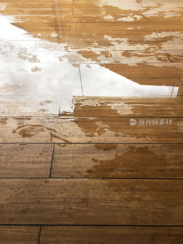木地板上有水坑。室外甲板表面潮湿