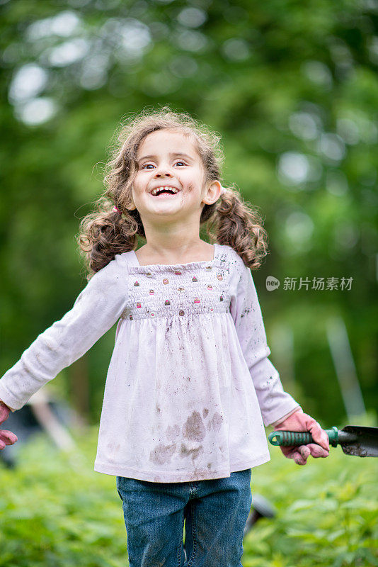 小女孩在她的后院花园快乐