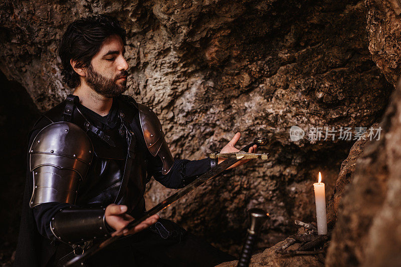 一个幻想的骑士在一个石洞里祈祷，用点燃的蜡烛把他的剑献给他自己做的祭坛的神秘肖像