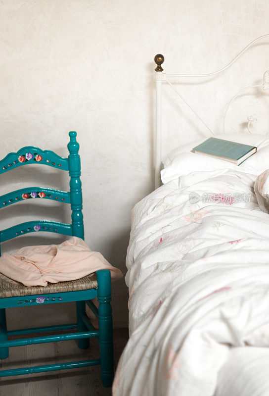 乡村卧室，蓝色的椅子，未整理的床