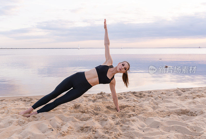 年轻的运动女孩在海边做健身瑜伽