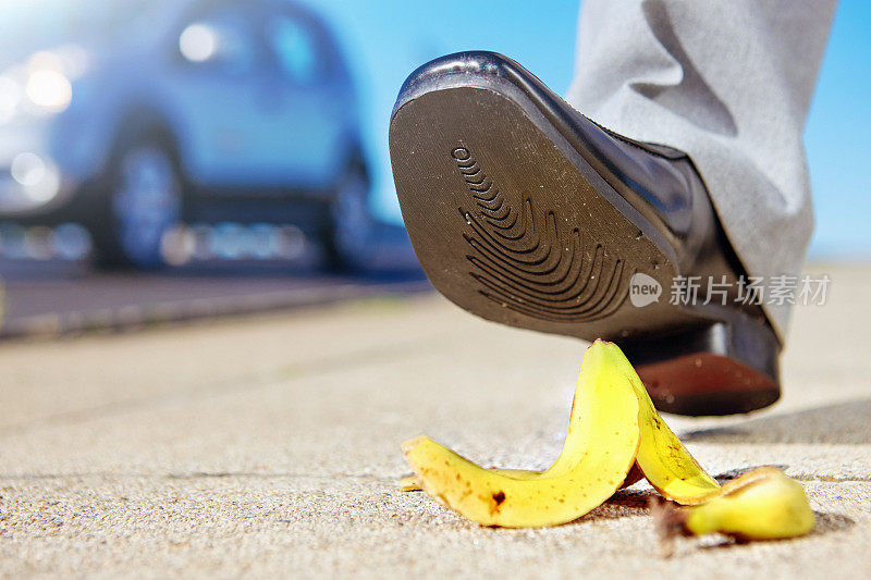 危险吧!穿着考究的男人的鞋子快要踩到香蕉皮了
