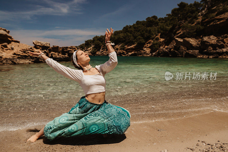 精神瑜伽女人在阳光明媚的海滩上跳着神圣的舞蹈