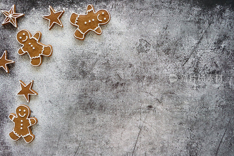 自制的形象，姜饼人和星星饼干冰镇白色，皇家糖衣在灰色背景，圣诞海报背景壁纸，高视图，复制空间