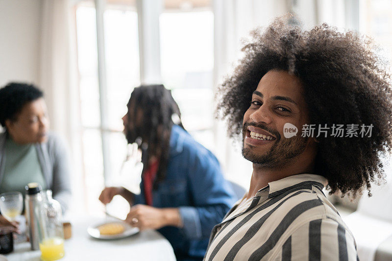 一个快乐的年轻人和家人在家里吃早餐