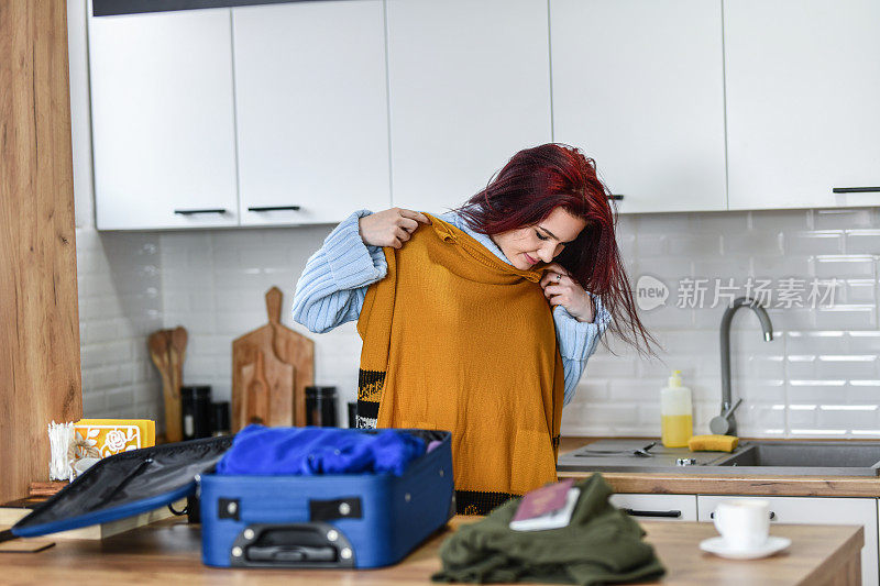 女性在打包旅行前检查衬衫是否合身