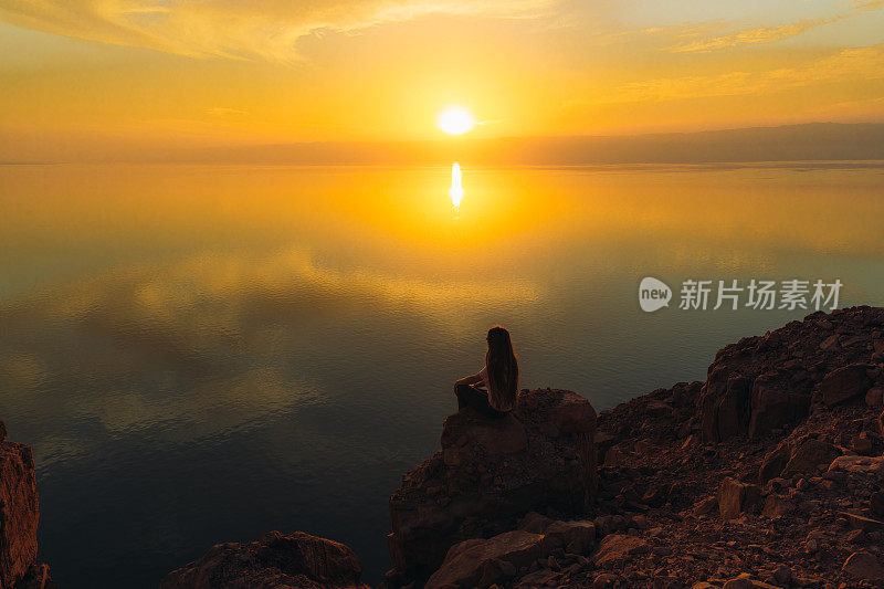 约旦死海上一个女人的剪影，她正在欣赏日落美景