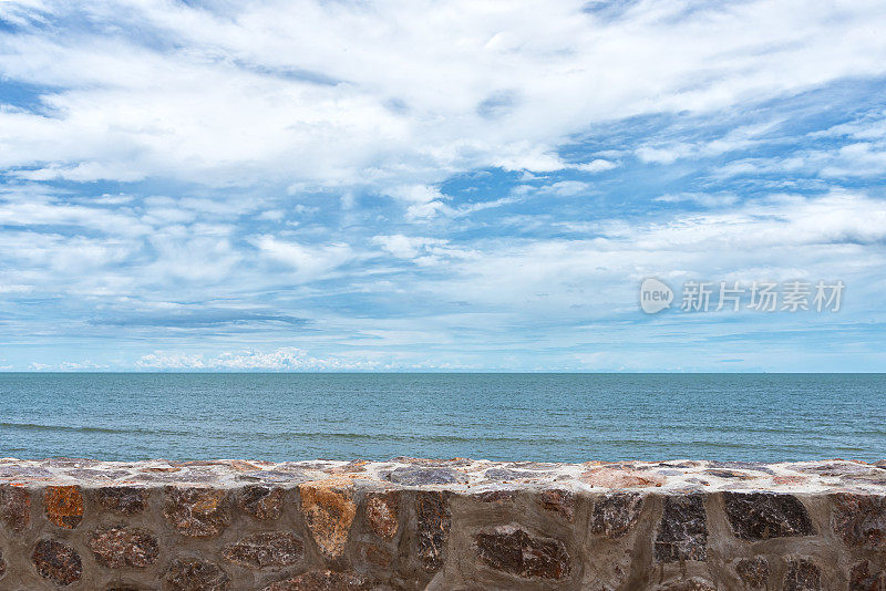 石墙与海，以云和天空为背景