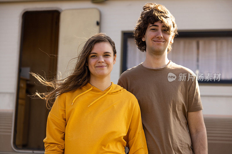 一对年轻夫妇在他们的露营车前的肖像