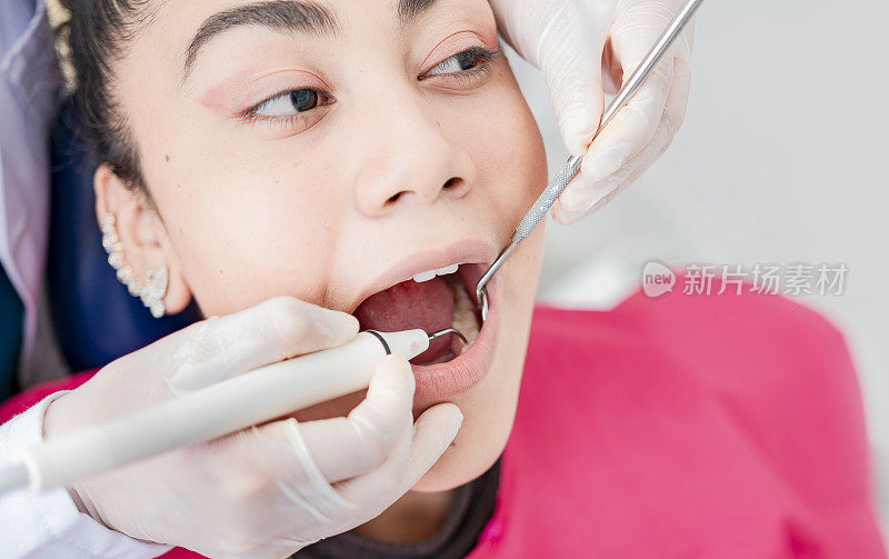牙科医生用挖掘机和牙科镜检查病人，牙科医生用挖掘机和牙科镜检查病人，牙科医生检查病人，牙科医生做牙科检查