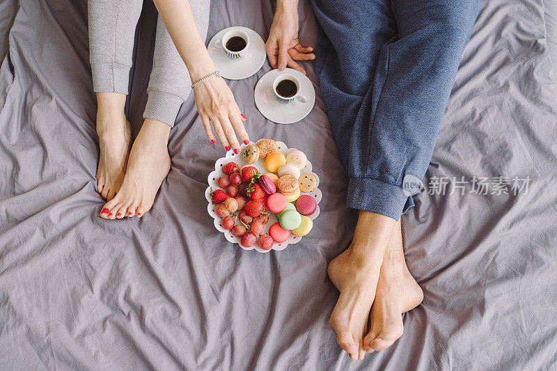 年轻的白人夫妇在床上吃浪漫的早餐