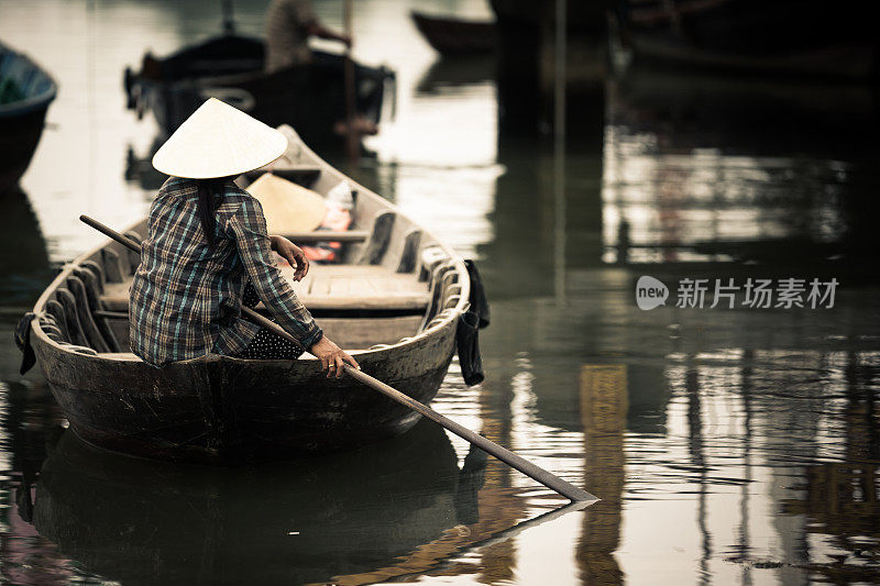 在船上戴着传统帽子的越南妇女