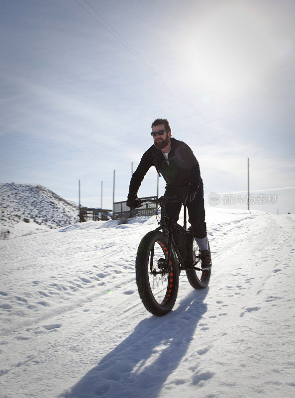 雪地里骑着胖墩墩自行车的男性。