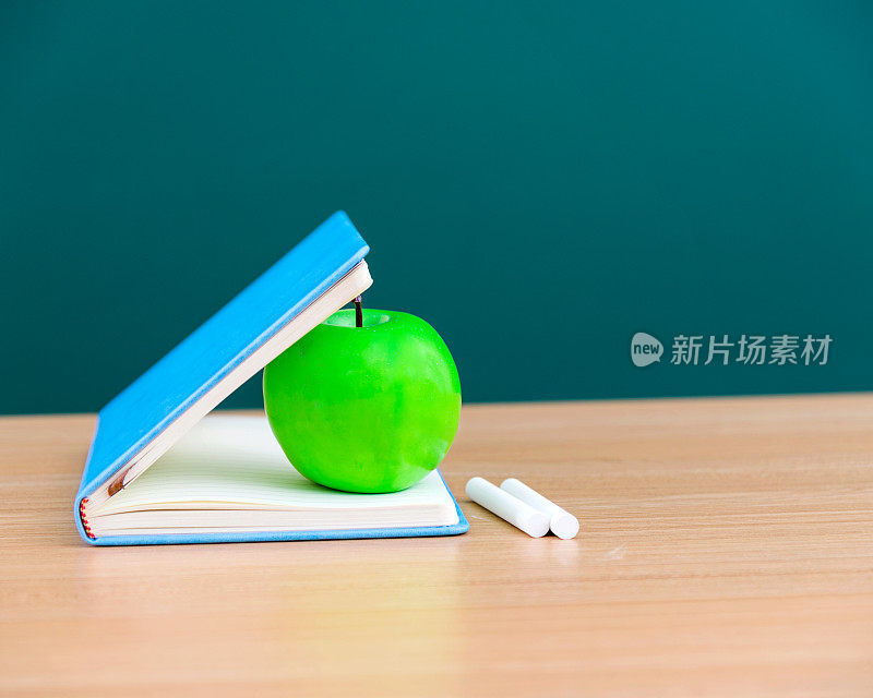 苹果和书挨着黑板