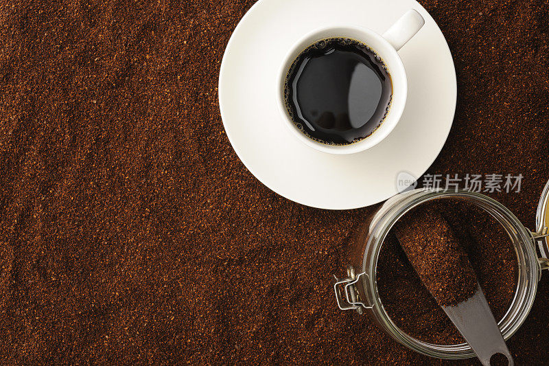 白咖啡杯里的黑咖啡和磨碎的咖啡豆