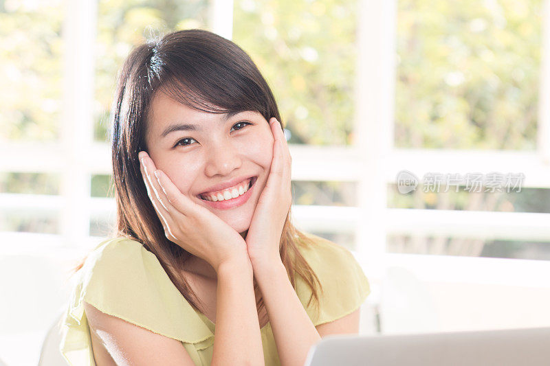 亚洲女孩在教室里用笔记本学习