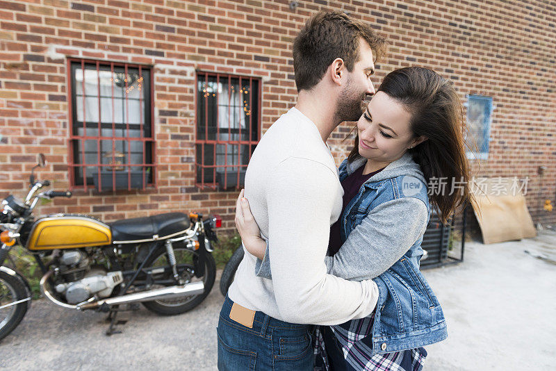 一对年轻夫妇在布鲁克林大街互相拥抱