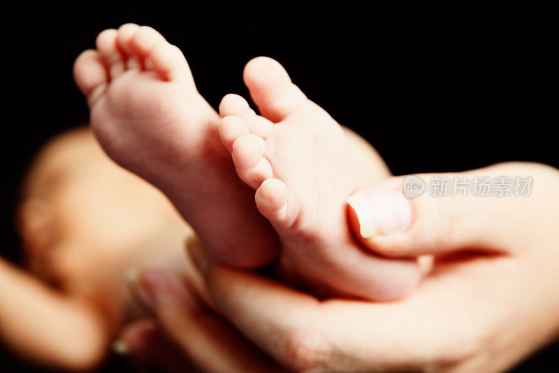 女人的手抱着小婴儿可爱的脚