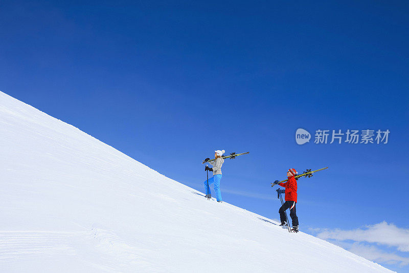 冬季运动朋友，男人和女人滑雪者携带着滑雪板